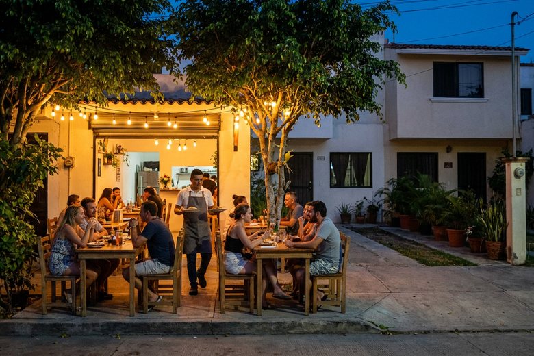 Evening sidewalk dining on a tree-lined residential street in the Versalles neighborhood of Puerto Vallarta