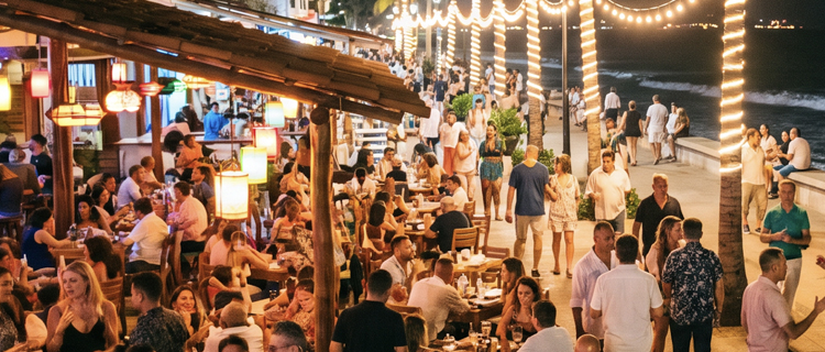 The Puerto Vallarta Malecon boardwalk lit up at night with bars and crowds