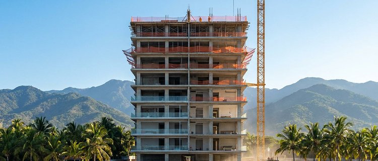New condominium tower under construction near the beach in Nuevo Nayarit with the Sierra Madre behind it