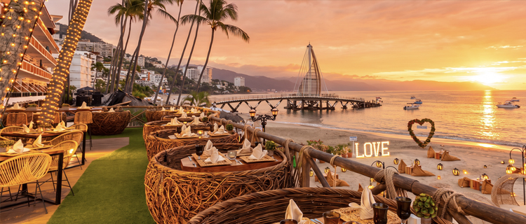 A beachfront palapa restaurant at sunset on Los Muertos beach in Puerto Vallarta