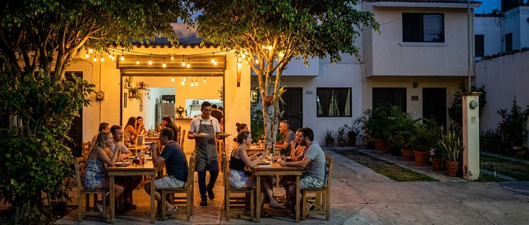 Evening sidewalk dining on a tree-lined residential street in the Versalles neighborhood of Puerto Vallarta
